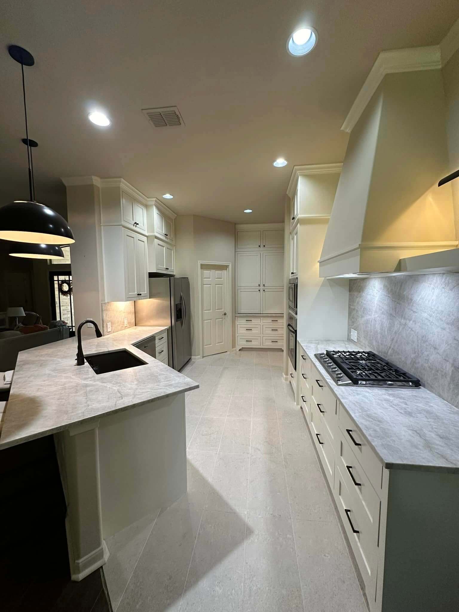Completed kitchen remodel in Helotes TX with gas cooktop and hood and custom cabinets
