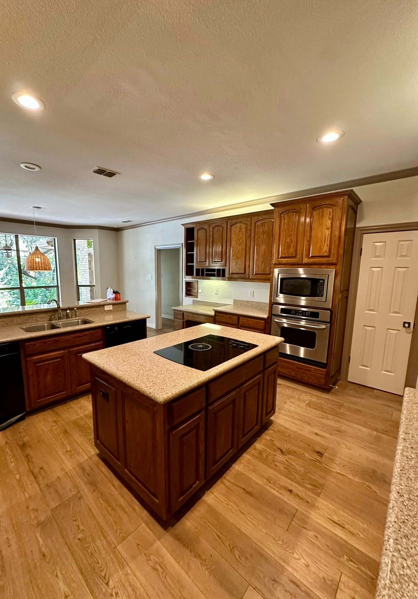 before image of dark oak cabinets and pink granite countertops in Fair Oaks Ranch TX kitchen remodel by Shaw Construction Services