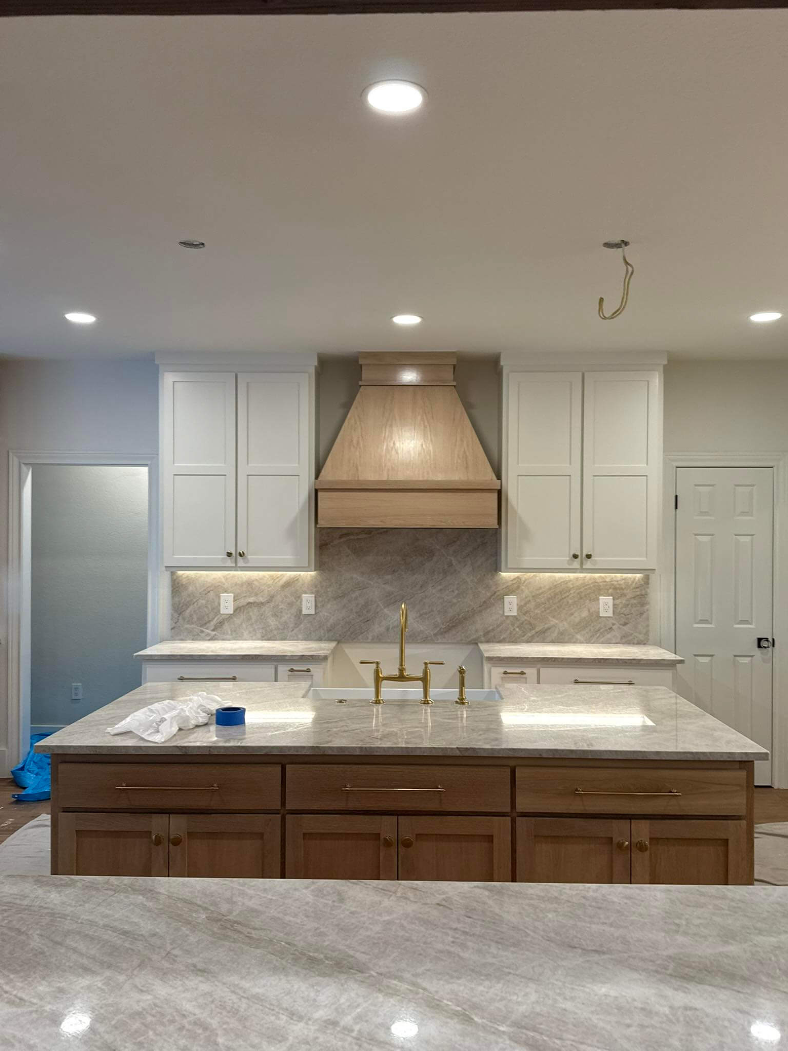 mid-project with painted custom kitchen cabinets and Taj Mahal countertops in Fair Oaks Ranch TX kitchen remodel by Shaw Construction Services